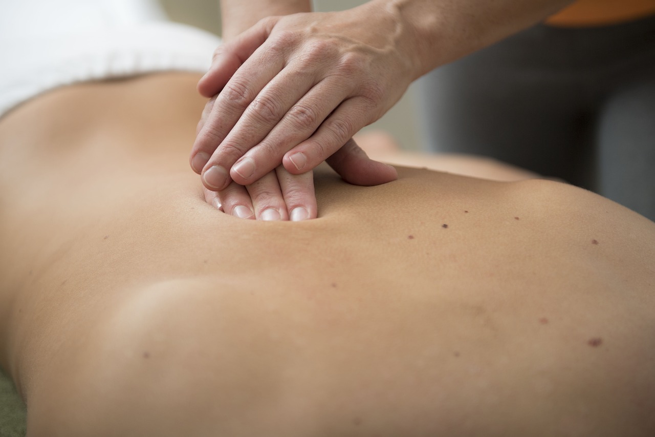 A therapist performing a back massage on a client, illustrating the soothing techniques used in Docklands massage services for muscle relief and tension reduction.