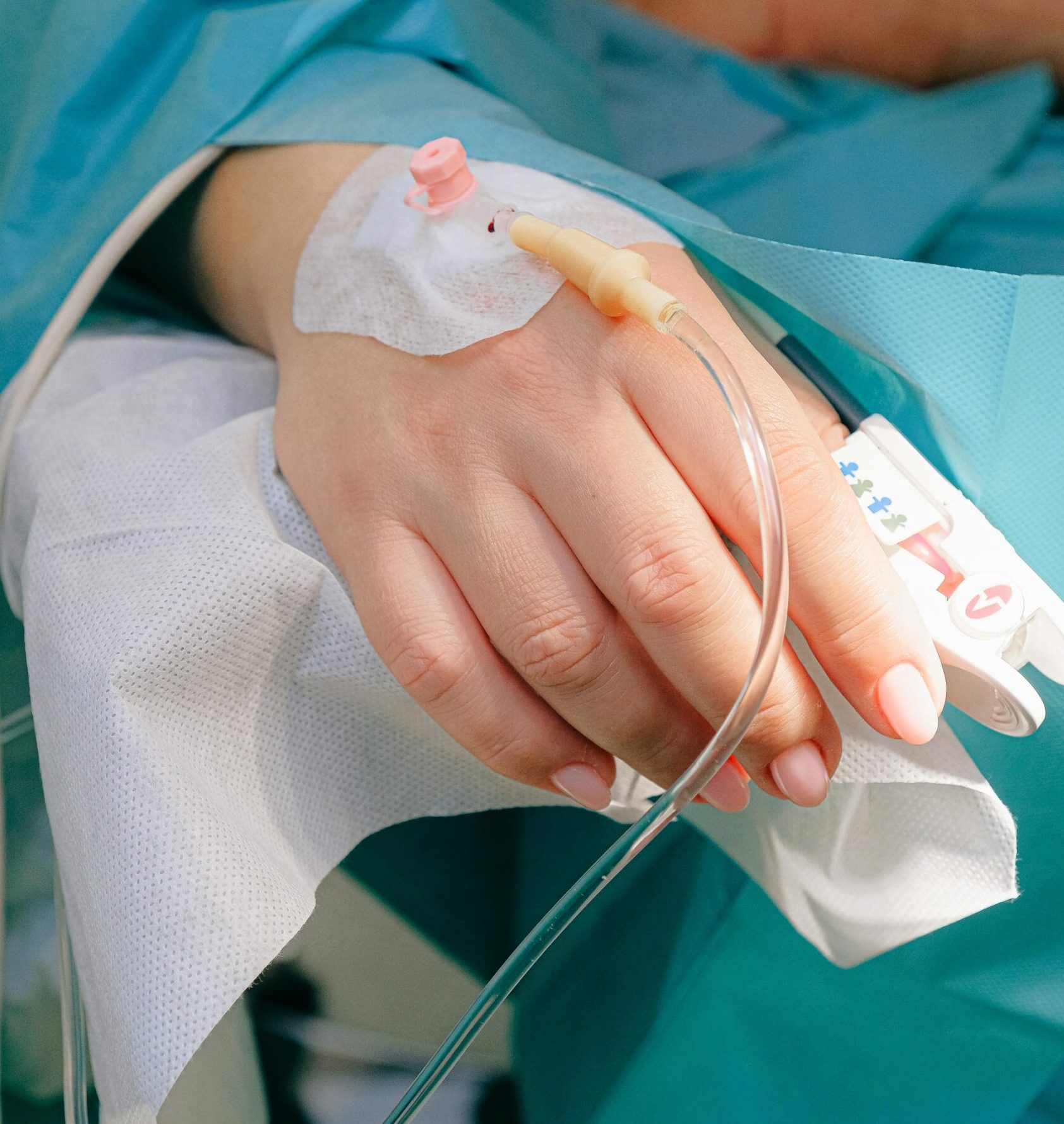 A close-up of a patient's hand with an IV, emphasizing relaxation and care, similar to the restorative effects of trigger point therapy in Melbourne.