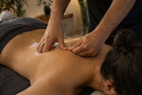 A professional massage therapist performs a targeted remedial treatment on a client's back in a tranquil Melbourne clinic setting.